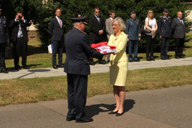 Die kanadische Botschafterin überreicht die kanadische Flagge an den Kommandeur des Kommandos Unterstützungsverbände der Luftwaffe (Quelle: Luftwaffe/LwUstgGrp Wahn)