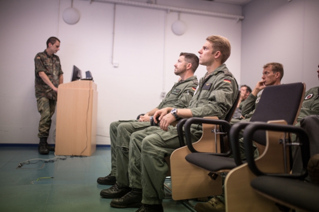 Flugschüler, Fluglehrer und andere Aircrews sitzen gemeinsam im Briefingraum. (Quelle: Luftwaffe/Falk Bärwald)